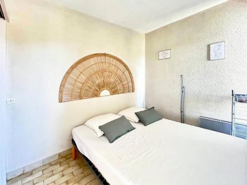 une chambre avec un lit blanc avec deux oreillers dessus dans l'établissement Résidence La Croisière - T2 proche plage MAE-5421, au Grau-du-Roi