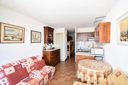 un salon avec un canapé et une cuisine dans l'établissement Résidence La Croisière - Studio cabine Croisière à Port Camargue MAE-5431, au Grau-du-Roi