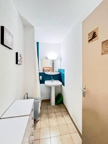 La petite salle de bains est pourvue d'un lavabo et d'un lavabo blanc. dans l'établissement Résidence Le Lagon Bleu - T2 dans résidence avec piscine MAE-6971, au Grau-du-Roi