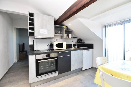 une cuisine avec une cuisinière et un micro-ondes dans l'établissement Résidence Les Suzannes - Appartement Suzanne 3 au Grau du roi MAE-6991, au Grau-du-Roi