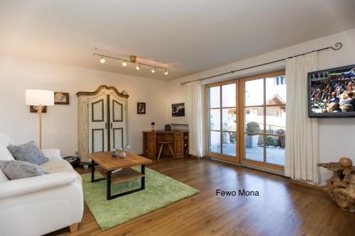 a living room with a white couch and a table at Ferienwohnung Mitteldorf in Oberammergau