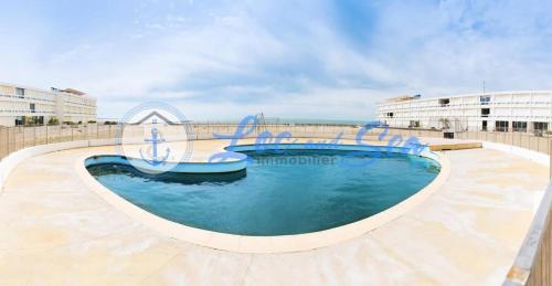 une grande piscine d'eau bleue au milieu dans l'établissement Résidence De La Mer - Studio standing avec jardin au Grau du Roi MAE-5451, au Grau-du-Roi
