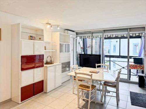 une cuisine et une salle à manger avec une table et une télévision dans l'établissement Résidence Le Lagon Bleu - Superbe T2 dans résidence avec piscine MAE-7011, au Grau-du-Roi