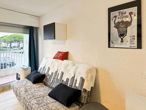 - un salon avec un canapé et une couverture de ville dans l'établissement Résidence La Croisière - Studio cabine 4 couchages MAE-5461, au Grau-du-Roi