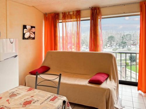 une chambre avec un lit avec des oreillers rouges et une fenêtre dans l'établissement Résidence Le Lagon Bleu - Superbe T2 au Grau du roi avec piscine MAE-6981, au Grau-du-Roi