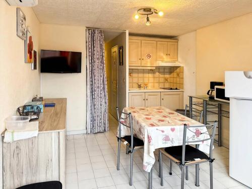 une cuisine avec une table et une cuisine avec une table et des chaises dans l'établissement Résidence Le Lagon Bleu - Superbe T2 au Grau du roi avec piscine MAE-6981, au Grau-du-Roi