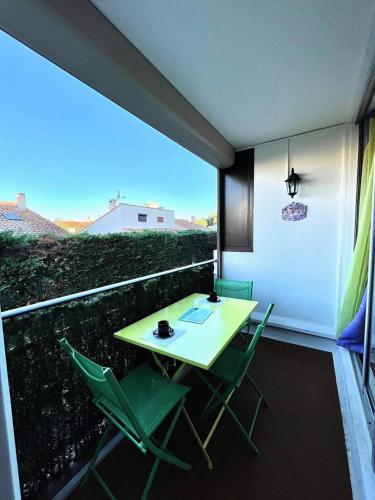 d'une table et de chaises vertes sur un balcon dans l'établissement Résidence Le Lagon Bleu - Studio cabine avec piscine au Grau du Roi MAE-7021, au Grau-du-Roi