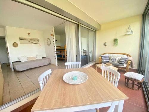 une table et des chaises en bois dans un salon dans l'établissement Résidence Les Jardins Du Port - Superbe T2 en rez de jardin dans résidence avec piscine MAE-7031, au Grau-du-Roi