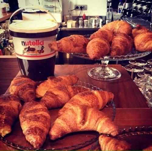 a table with a tray of pastries and a cup of coffee at Hotel Piero Della Francesca in Arezzo