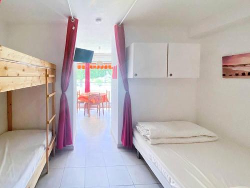- une chambre avec 2 lits superposés et une salle à manger dans l'établissement Résidence Le Méridien - Studio cabine 4 couchages proche plage MAE-7041, au Grau-du-Roi