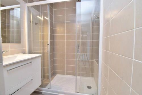 une salle de bain avec une douche avec une porte vitrée dans l'établissement Résidence Le Vincent - Rez de jardin proche plage et centre ville du Grau du roi MAE-7051, au Grau-du-Roi