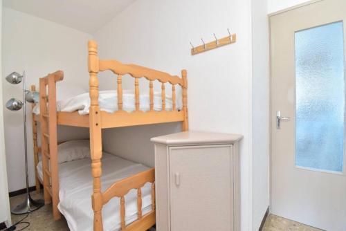 une chambre avec un lit superposé avec une échelle dans l'établissement Résidence Le Vincent - Rez de jardin proche plage et centre ville du Grau du roi MAE-7051, au Grau-du-Roi
