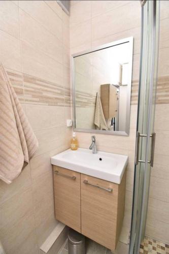 une salle de bain avec un lavabo et un miroir dans l'établissement Résidence Le Chabian - Port Camargue T2 rénové, tout équipé, en 1ère ligne mer, plage sud à 50m, piscine, tennis, climatisé MAE-7061, au Grau-du-Roi