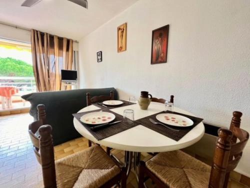 une salle à manger avec une table et des chaises blanches dans l'établissement Résidence La Lagune - Appartement T2 vue mer au Grau du roi MAE-7081, au Grau-du-Roi