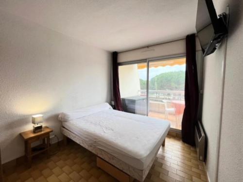 une petite chambre avec un lit et une fenêtre dans l'établissement Résidence La Lagune - Appartement T2 vue mer au Grau du roi MAE-7081, au Grau-du-Roi