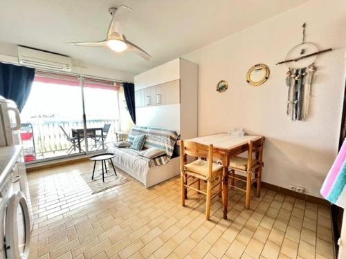 une cuisine et un salon avec une table et un canapé dans l'établissement Résidence Los Amigos Ii - Studio 3 couchages proche plage MAE-7091, au Grau-du-Roi