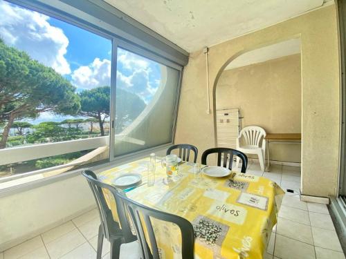 une salle à manger avec une table et des chaises et une fenêtre dans l'établissement Résidence Le Chabian - Studio cabine 5 couchages dans résidence avec piscine MAE-7121, au Grau-du-Roi