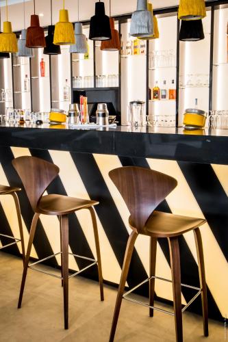 a bar with three chairs at a counter with lights at Simon Hotel in Fort-de-France