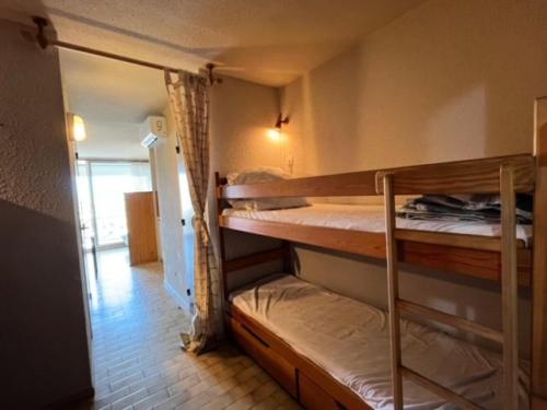 Cette chambre comprend 2 lits superposés et un couloir. dans l'établissement Résidence Le Lagon Bleu - Studio cabine dans résidence avec piscine MAE-7131, au Grau-du-Roi
