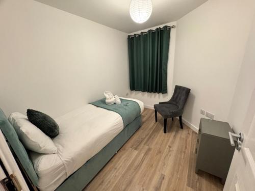 a small bedroom with a bed and a chair at Town centre 1 Cozy king size bed ensuit shower in Huntingdon