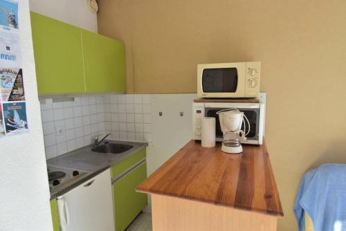 une cuisine avec un comptoir, un four micro-ondes et un mixeur dans l'établissement Résidence Le Grand Pavois - Studio cabine vue port à Port Camargue MAE-7171, au Grau-du-Roi