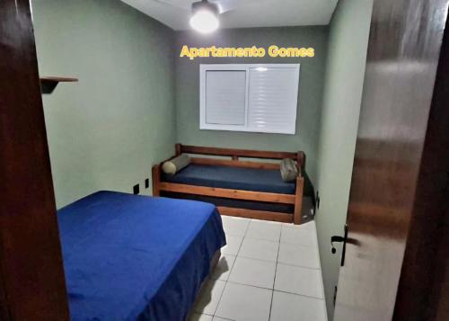 a small bedroom with a bed and a window at Apartamento Gomes Wi-Fi Aviação P Grande in Praia Grande