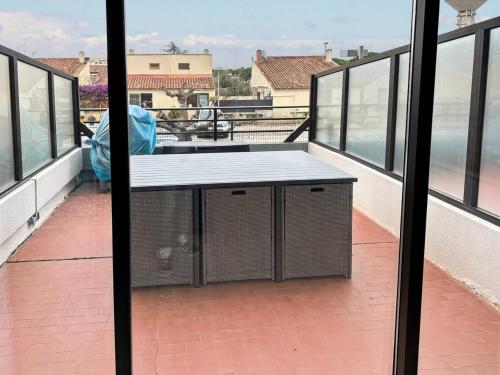 - un balcon avec une table au-dessus d'un bâtiment dans l'établissement Résidence Le Lagon Bleu - Studio 4 couchages dans residence avec piscine MAE-7201, au Grau-du-Roi