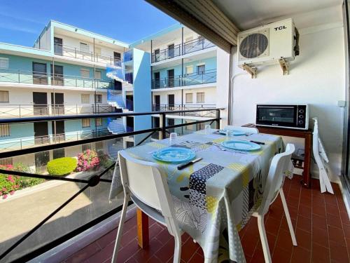 - une table et des chaises sur le balcon d'un appartement dans l'établissement Résidence Le Lagon Bleu - Studio cabine dans résidence avec piscine MAE-7221, au Grau-du-Roi