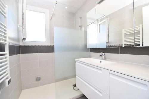 une salle de bain blanche avec un lavabo et un miroir dans l'établissement Résidence Les Suzannes - Superbe T3 au Grau du Roi MAE-9841, au Grau-du-Roi