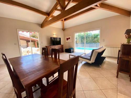 une salle à manger avec une table et des chaises en bois dans l'établissement Résidence Fr15-le Grau Du Roi - Maison flamants roses avec piscine Grau du roi MAE-9861, au Grau-du-Roi