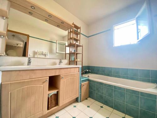 La salle de bains est pourvue d'une baignoire, d'un lavabo et d'une baignoire. dans l'établissement Résidence Fr15-le Grau Du Roi - Maison flamants roses avec piscine Grau du roi MAE-9861, au Grau-du-Roi