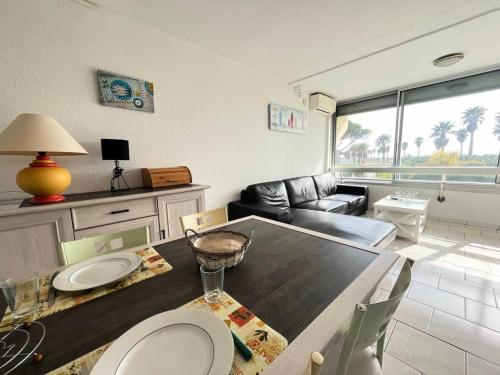 un salon avec une table et un canapé dans l'établissement Résidence Le Chabian - Appartement 8 couchages au Grau du roi MAE-9851, au Grau-du-Roi