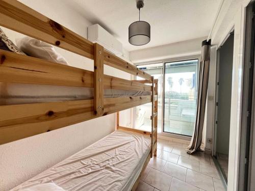 Ce lit superposé se trouve dans un dortoir doté d'une fenêtre. dans l'établissement Résidence Le Chabian - Appartement 8 couchages au Grau du roi MAE-9851, au Grau-du-Roi