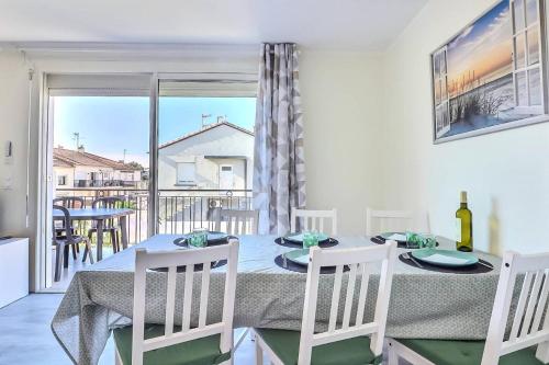 une salle à manger avec une table et des chaises et un balcon dans l'établissement Résidence Les Suzannes - Appartement T3 moderne au Grau du roi MAE-9871, au Grau-du-Roi