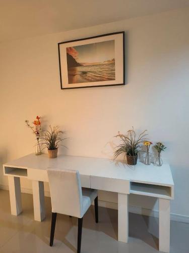 a white table with a chair and plants on it at Baan Klang Condo in Hua Hin in Hua Hin