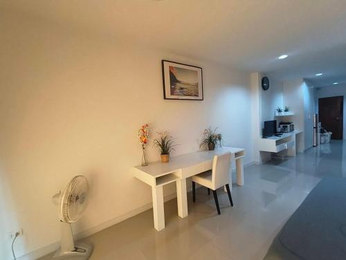 a dining room with a white table and a fan at Baan Klang Condo in Hua Hin in Hua Hin
