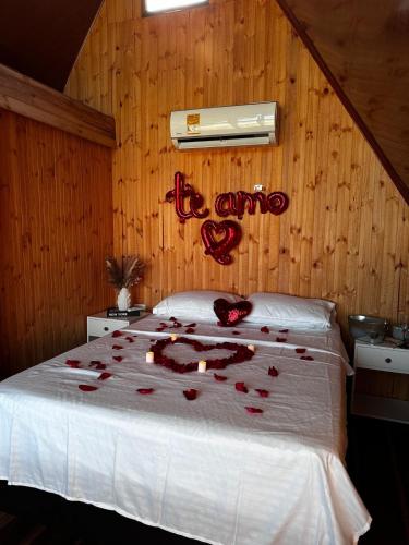 a bedroom with a bed with red roses on it at Playa Aescondidas in Ríohacha