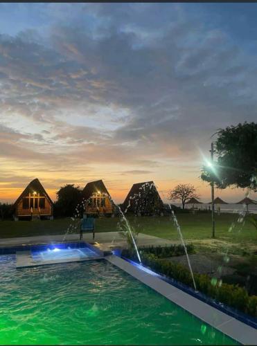 a swimming pool with a fountain in front of tents at Playa Aescondidas in Ríohacha