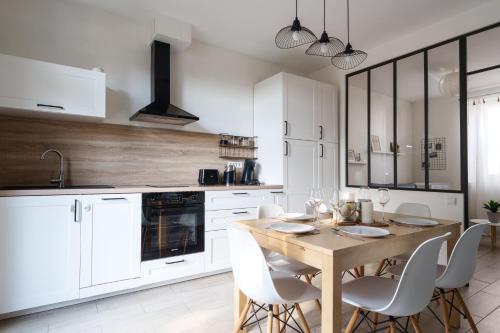 une cuisine avec une table en bois et des armoires blanches dans l'établissement Maison 5 p hyper centre Amboise #parking #terrasse, à Amboise