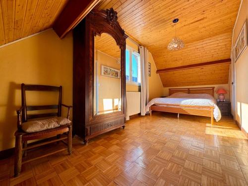 une chambre avec un lit et une chaise dans une pièce dans l'établissement Antipodes, maison avec parking face au port, à Saint-Valery-sur-Somme