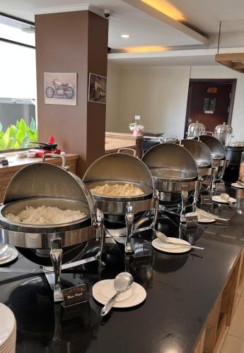 a row of food pans sitting on top of a counter at Point C Hotel in Bandung