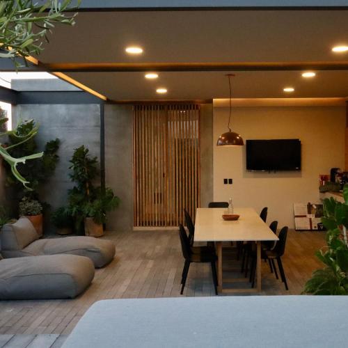 a living room with a table and chairs and a tv at Hotel Boutique Sina in Guadalajara
