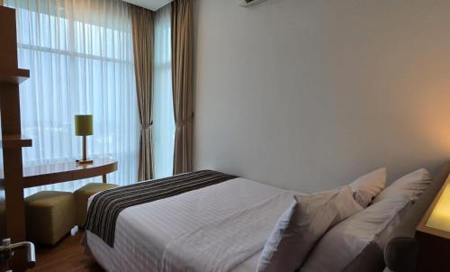 a bedroom with a bed and a large window at Point C Hotel in Bandung