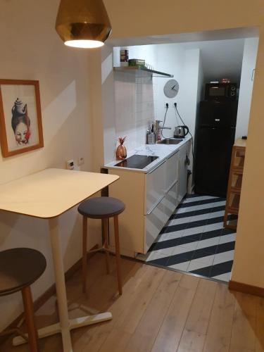 La cuisine est équipée d'une table, d'un évier et d'un réfrigérateur. dans l'établissement Nansouty terrasse, à Bordeaux