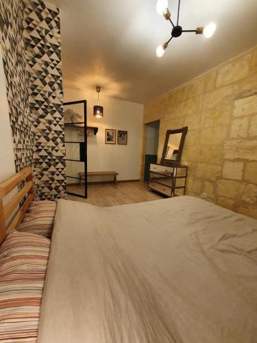 une chambre avec un grand lit et un mur en pierre dans l'établissement Nansouty terrasse, à Bordeaux