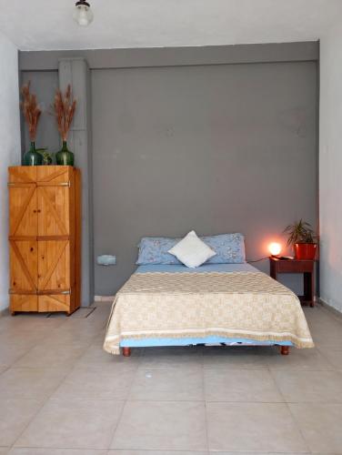 Un dormitorio con una cama y una cómoda de madera. en Loloh, en Formosa