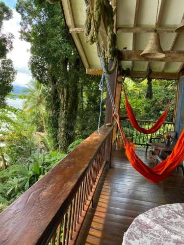a hammock on a porch with a view of the ocean at Ecolodge el Arca Bahia Solano in Bahía Solano