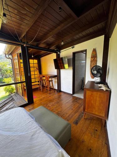 a bedroom with a bed and a table with a television at Guarda do Embau Gran Kahuna in Palhoça