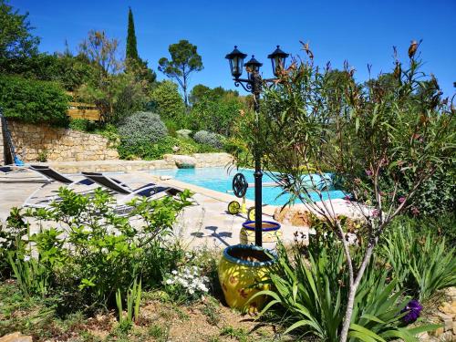 une piscine avec un éclairage de rue à côté d'un jardin dans l'établissement L'Olivade, à Entrecasteaux
