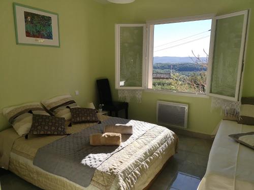 une chambre avec un lit et une grande fenêtre dans l'établissement L'Olivade, à Entrecasteaux